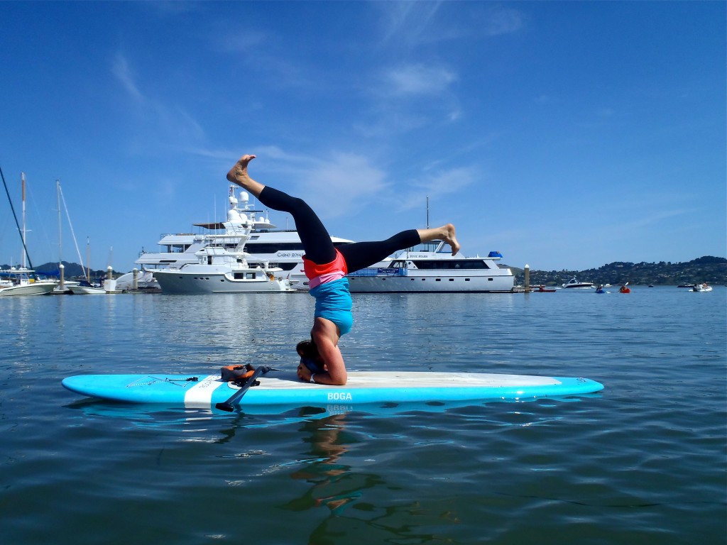 Instructor Leigh Claxton demonstrates a Sirsha-asan, Sausalito harbor. Photo courtesy of OnBoard SUP