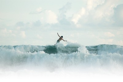 Photo of surfer falling, on a wave, in the distance