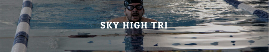 Swimmer in pool with words Sky High Tri in front of him