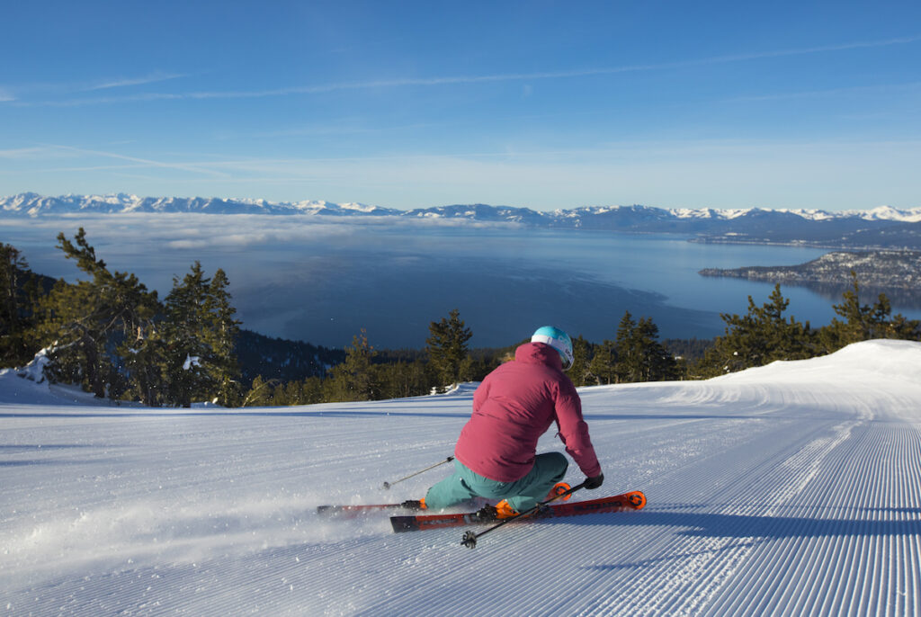 Woman skiing fresh corduroy at Diamond Peak with a view of the lake in the background