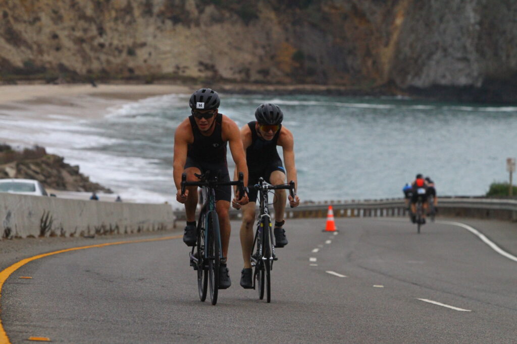 bikers going up a hill during the Pacific-Coast-Triathlon