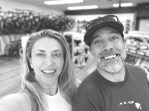 A black and white selfie of Crystal and Jeff in their bike shop. 