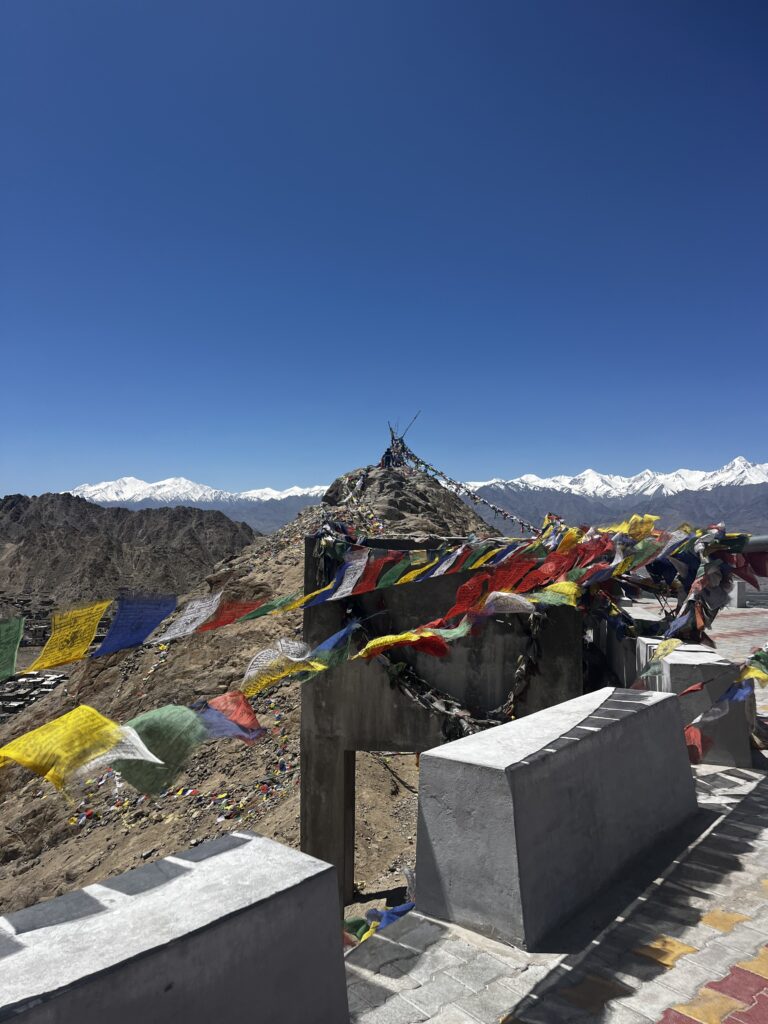 Prayer flags blowing in the wind on a mountain top temple.