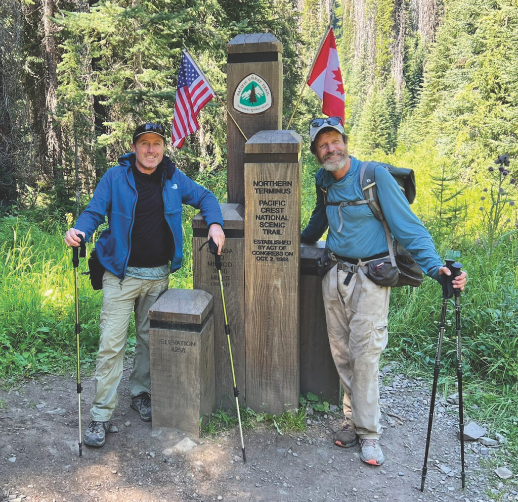 Hikers stand in front of PCT end terminus.