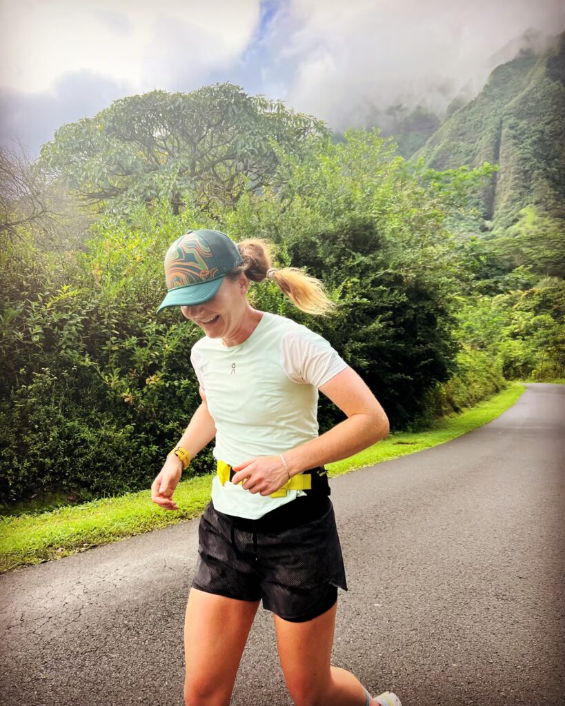 Alyssa Clark smiling while running on the roads in Hawaii